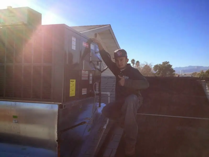 HVAC technician performing HVAC Inspection on a rooftop unit in Hinsdale